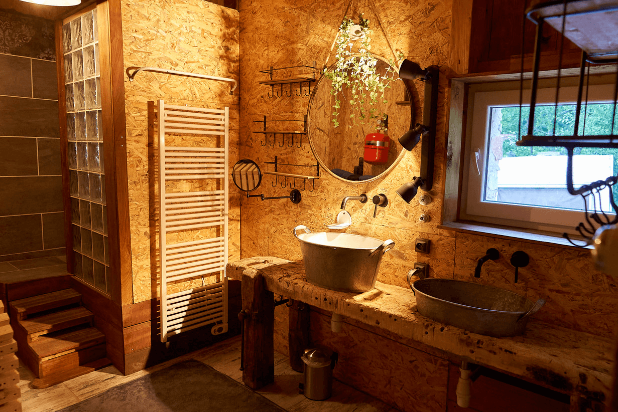 Une salle de bain au design unique avec un mur recouvert de partitions musicales, une baignoire en bois et des décorations éclectiques, éclairée par une lumière chaleureuse.